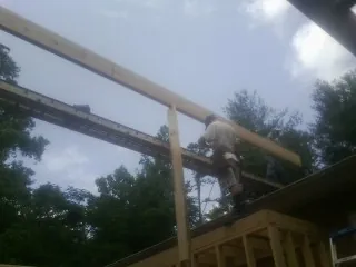 Carpenter setting a ridge beam over a new addition frame — Ice Dam Removal by Roofing Brothers in House Springs