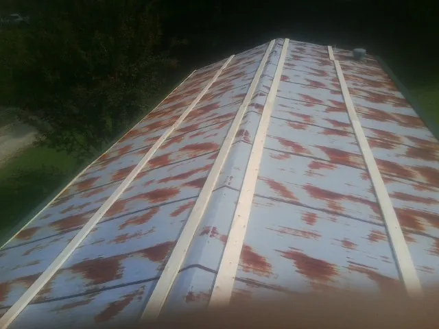Rusted metal roof panels with new wood purlins before replacement — Storm Damage Roof Repair in House Springs by Roofing Brothers