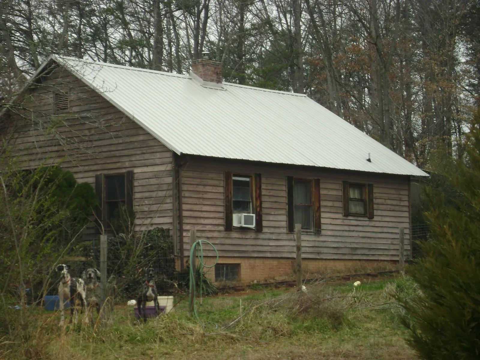 White metal roof on an old wood sided farmhouse, from a Metal Roof Installation job in House Springs